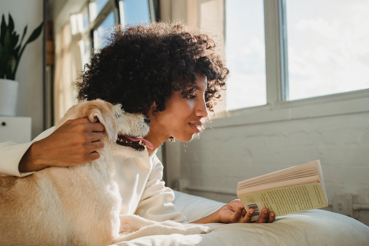 woman reading next to her dog
